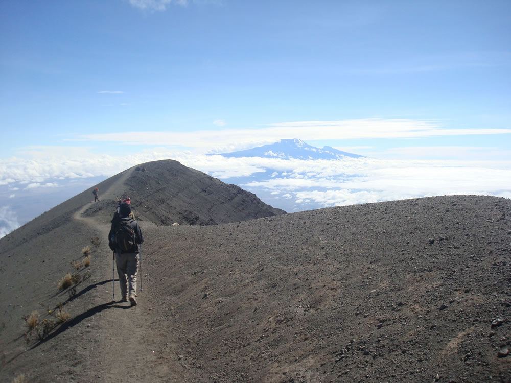 Mount Merus summit ridge with Kilimanjaro ahead in the distance